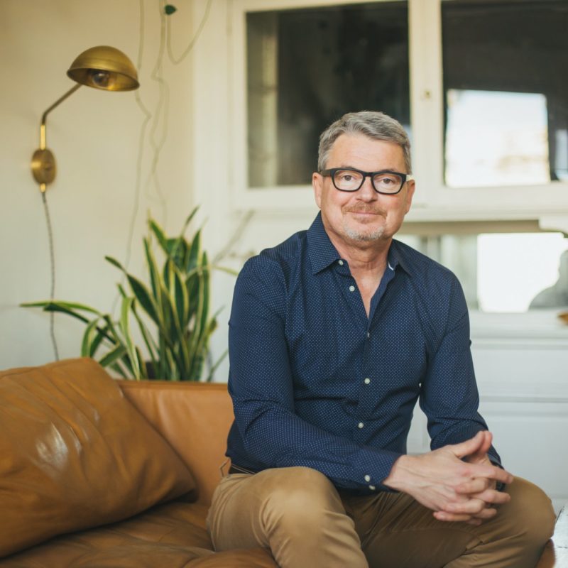 Dr. Mark Burhenne sitting on sofa